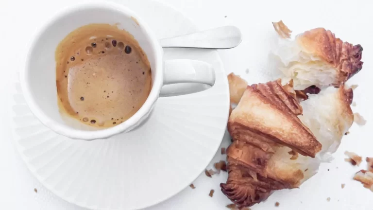 A cup of coffee and a croissant